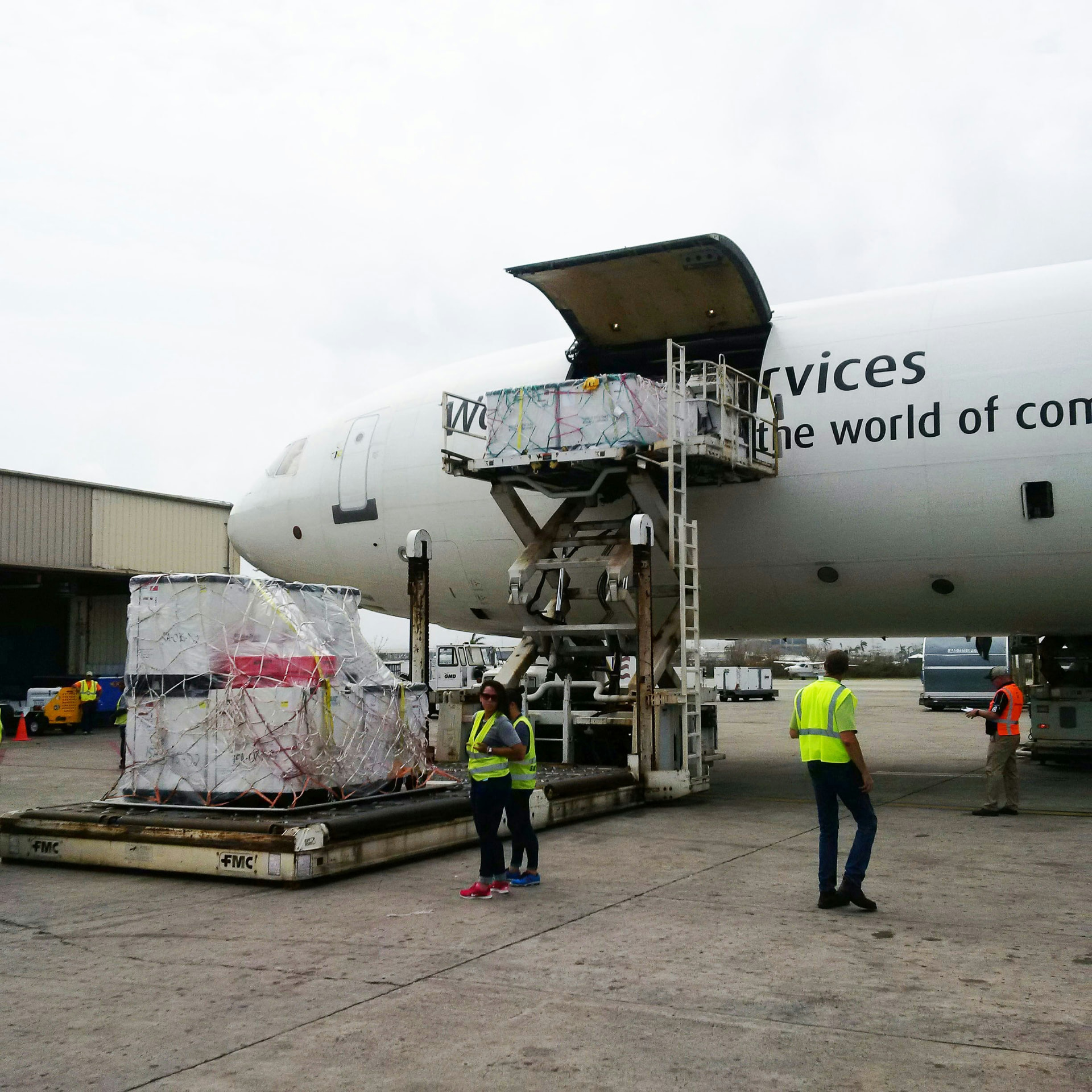 Wrapped air cargo pallet being raised into a freight aircraft